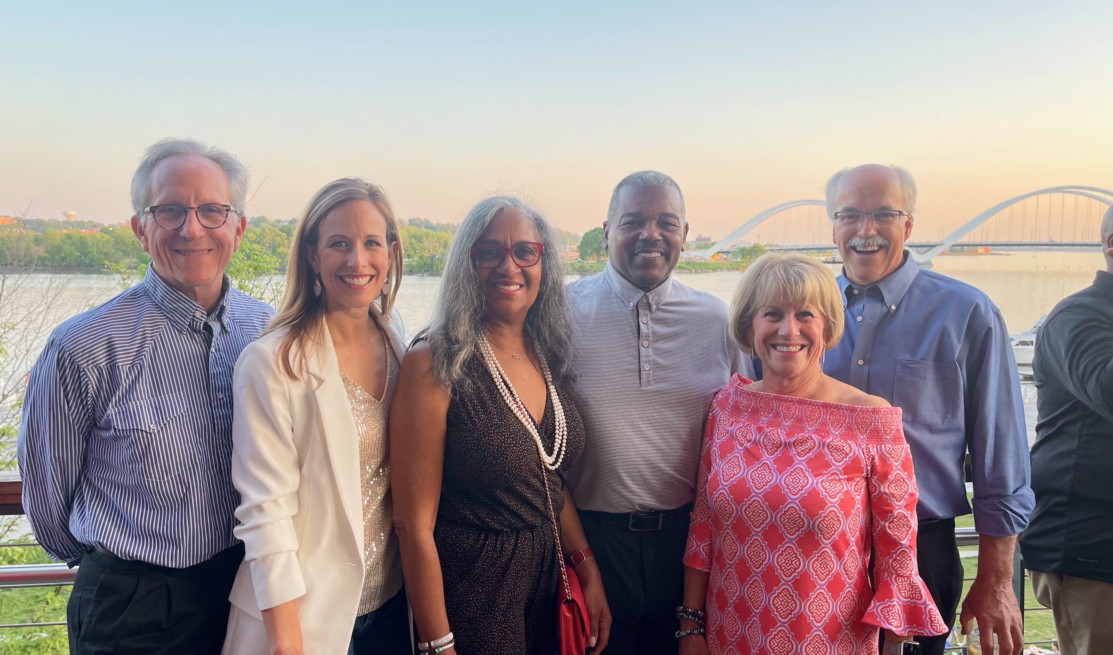 image of Nancy posing for a photo with 6 other people over looking the river